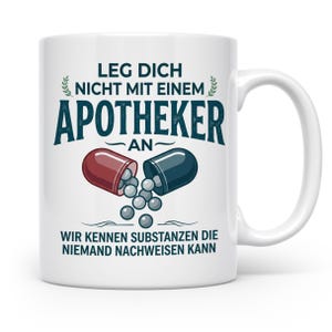 Könnte beinhalten: Ein weißer Keramikbecher mit einer Grafik einer geteilten rot-dunkelblauen Kapsel, aus der graue Pillen fallen. Der Text lautet: LEG DICH NICHT MIT EINEM APOTHEKER AN WIR KENNEN SUBSTANZEN DIE NIEMAND NACHWEISEN KANN. Das Design ist mittig platziert.
