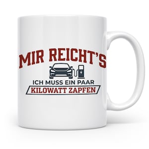 Könnte beinhalten: Ein weißer Keramikbecher mit einer Grafik eines Elektroautos an einer Ladestation. Der Text lautet "MIR REICHT'S" in Rot, gefolgt von "ICH MUSS EIN PAAR KILOWATT ZAPFEN" in Schwarz und Rot, ergänzt durch ein schwarzes Auto- und Ladesäulensymbol.