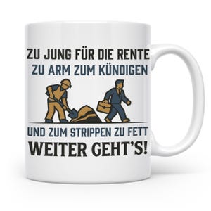 Könnte beinhalten: Ein weißer Keramikbecher mit einer Grafik eines Bauarbeiters mit Schaufel und einer Person im Anzug mit Aktentasche. Der Text lautet: ZU JUNG FÜR DIE RENTE ZU ARM ZUM KÜNDIGEN UND ZUM STRIPPEN ZU FETT WEITER GEHT'S! in schwarzer und blauer Schrift.