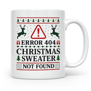 Könnte beinhalten: Ein weißer Keramikbecher mit einem festlichen Design in Rot und Grün. Die Grafik zeigt ein rotes Warndreieck, zwei grüne Rentiere und den Text ERROR 404 CHRISTMAS SWEATER NOT FOUND in schwarzen Großbuchstaben auf der Vorderseite.