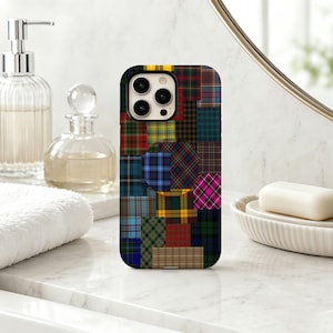 Puede incluir: Una funda rectangular para smartphone con un diseño de patchwork multicolor compuesto por varios patrones de tartán y cuadros. La disposición en cuadrícula incluye cuadrados y rectángulos en tonos rojo, azul, verde, amarillo, rosa y marrón.