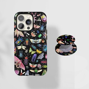 May include: Black phone case and matching pop socket featuring a colorful insect pattern. The design includes various beetles, butterflies, and other insects in a vibrant array of colors against a black background. The phone case has a camera cutout.