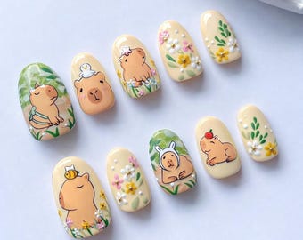 Uñas postizas hechas a mano con diseño de capibara y estampado floral de animales.