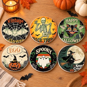 May include: A set of six round ceramic coasters featuring Halloween designs including a bat on a web, a skeleton, a black cat, a jack-o'-lantern with the text BOO, a ghost with the text SPOOKY, and a witch on a broomstick with the text Keep Creepin.