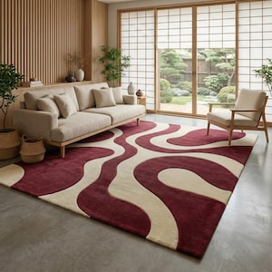 Può includere: Un grande tappeto rettangolare con un motivo ondulato nei colori bordeaux e crema. Il tappeto si trova in un soggiorno con un divano beige, una sedia in legno e luce naturale da una grande finestra. Le dimensioni del tappeto sono in centimetri.