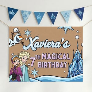Puede incluir: Una pancarta de cumplea&ntilde;os con el texto "Xaviera's 7th Magical Birthday" con ilustraciones de personajes de la pel&iacute;cula Frozen, incluyendo a Olaf, Elsa y Anna. Una guirnalda de banderines azules con dise&ntilde;os de copos de nieve y castillos cuelga encima.