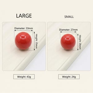 Puede incluir: Dos pomos esf&eacute;ricos rojos etiquetados como LARGE y SMALL. El pomo grande tiene un di&aacute;metro de 33mm, una altura de 35mm y un peso de 43g. El pomo peque&ntilde;o tiene un di&aacute;metro de 27mm, una altura de 28mm y un peso de 24g, indicados claramente.