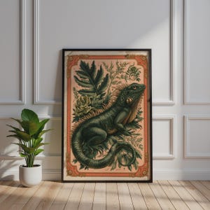 Op de afbeelding: Een ingelijste rechthoekige wandkunstprint met een gedetailleerde illustratie van een groene leguaan tussen weelderig gebladerte. Het kunstwerk is geplaatst tegen een zachte perzikkleurige achtergrond en omsloten door een sierlijke rode rand.