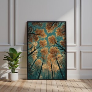 May include: A rectangular wall art print in a black frame featuring a low-angle view of tall trees with golden-orange autumn leaves against a teal sky. The artwork displays a dense forest canopy looking upward, capturing the contrast between the warm foliage and the cool blue-toned atmosphere of the sky.