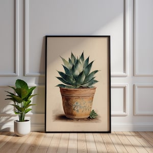 Peut inclure: Une impression encadrée à l'aquarelle d'une plante d'agave dans un pot en terre cuite. La plante a des feuilles épineuses bleu-vert. Le pot est décoré d'un motif floral. L'impression est présentée sur un fond crème et encadrée en noir.