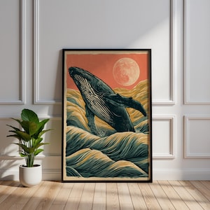 May include: A framed vertical wall art print featuring a dark blue humpback whale breaching out of stylized, layered teal and gold ocean waves against a solid coral-orange sky with a large, textured pale moon positioned in the upper right corner.