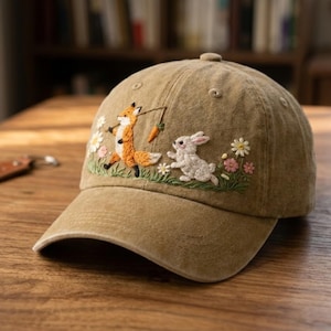 Puede incluir: Una taza de cerámica blanca con un asa negra y el texto "But First, Coffee" en negrita negra. La taza se encuentra sobre un fondo borroso, sugiriendo un ambiente acogedor.