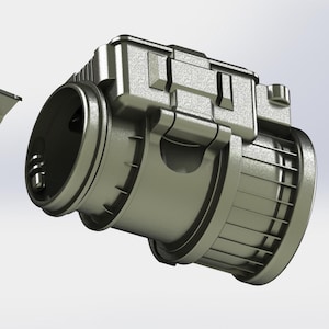 May include: A metallic gray, industrial-style component with a cylindrical body and a rectangular top section. The design features multiple ridges and a hinged element, suggesting a mechanical or engineering application. The object is set against a plain white background.