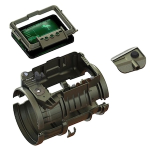 May include: An exploded view of a military-style device, showcasing its internal components. The device is primarily olive drab, with a screen displaying a green graphic. The components are arranged to highlight the internal structure and design of the device.