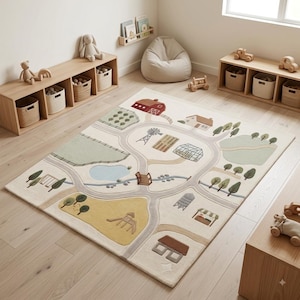 May include: A rectangular area rug featuring a cream-colored background with a printed farm-themed map. The design includes gray winding roads, a red barn, green fields, a blue pond, a windmill, a greenhouse, trees, and various small farm buildings.