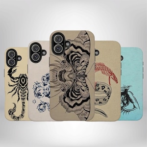 May include: Five rectangular phone cases arranged in a row, each featuring a unique graphic illustration. Designs include a black scorpion, a blue abstract pattern, a large moth, a red snake skeleton, and a black eye on a light blue background.