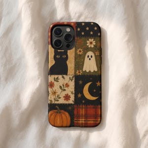May include: A smartphone case featuring a patchwork design with six distinct squares. The panels display a black cat, a white ghost, a crescent moon with stars, a pumpkin, floral patterns, and a red and orange plaid print in a grid layout.