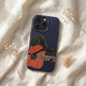 May include: A dark navy blue smartphone case featuring a graphic illustration of a black cat resting on an orange acoustic guitar. The cat has yellow eyes and is positioned across the guitar neck and body. The case has a triple camera cutout.