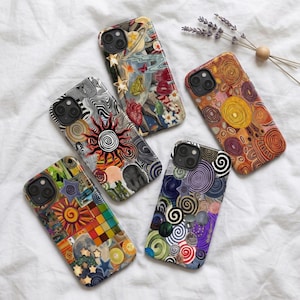 May include: Five smartphone cases featuring diverse artistic designs. One displays a sun with black and white swirls, another shows celestial bodies and a frog, one has warm-toned concentric circles, one features a colorful grid, and one has purple spirals.