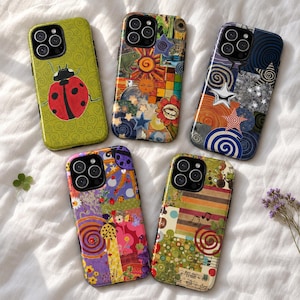 May include: Five smartphone cases with distinct designs: one with a ladybird on a green swirl background, one with a colourful sun and star collage, one with blue and orange swirls and stars, one with a purple floral ladybird pattern, and one with stripes.