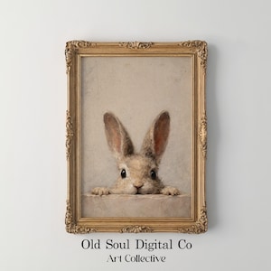 Peut inclure: Une impression encadrée de style vintage représentant un lapin curieux avec de longues oreilles, regardant par-dessus un rebord. L'œuvre est encadrée dans un cadre doré orné. Le texte "Old Soul Digital Co Art Collective" est en bas.