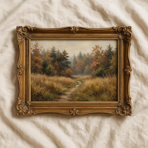 May include: A rectangular landscape painting in an ornate, antique gold-toned frame. The artwork depicts a narrow dirt path winding through a field of tall, golden-brown grasses toward a dense forest with trees displaying autumn foliage in shades of orange.
