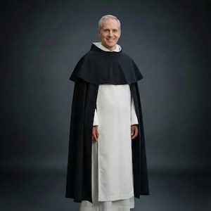 Puede incluir: Una persona con un hábito religioso tradicional. El atuendo incluye una túnica blanca, una capa negra y una capucha blanca. La persona sonríe, sobre un fondo gris oscuro. La ropa parece estar hecha de una tela sencilla y duradera.