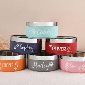 Puede incluir: Seis cuencos personalizados para mascotas, apilados. Cada cuenco tiene un borde plateado y un color diferente: naranja, azul marino, rojo, gris, azul claro y rosa. Nombres y huellas de patas.