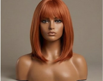 May include: A copper-colored wig with a blunt cut and bangs is displayed on a mannequin head and shoulders. The wig has a smooth, straight texture and a natural-looking appearance. The mannequin has a neutral expression and is set against a neutral background.