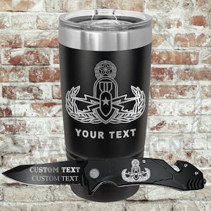 May include: Black insulated tumbler with a silver rim and lid, featuring a silver emblem and the text "YOUR TEXT". A black pocket knife with "CUSTOM TEXT" is placed in front of the tumbler.