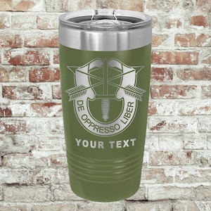 Puede incluir: Vaso térmico aislado verde oliva con tapa plateada. El vaso presenta un emblema plateado con una espada, flechas y el texto "DE OPPRESSO LIBER" y "YOUR TEXT". El vaso es cilíndrico y tiene un diseño acanalado.