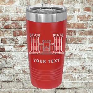 May include: A red insulated tumbler with a silver rim and lid. The tumbler features a silver graphic of a building with the text "YOUR TEXT" below it. The tumbler is cylindrical with horizontal grooves near the base.