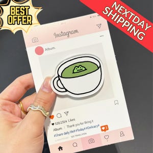 May include: A white sticker with a cartoon cup of green liquid and a frog design, set against a pink Instagram-themed background. The image includes the text "BEST OFFER" and "NEXTDAY SHIPPING".