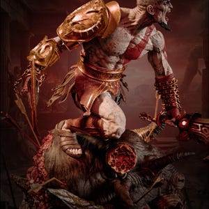 May include: A detailed collectible statue of a muscular warrior with pale skin and a red tattoo, wearing gold shoulder armour and bracers, standing atop a defeated creature. The figure holds a glowing sword and features intricate metallic details.