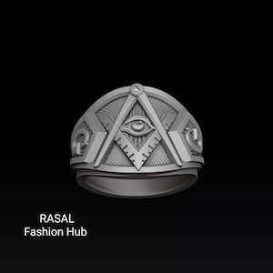 May include: A silver ring featuring a Masonic symbol with an all-seeing eye, compass, and square design. The ring has a detailed, geometric pattern and the text "RASAL Fashion Hub" is visible.
