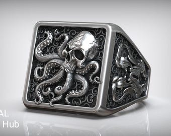 Peut inclure: Bague argentée à face rectangulaire ornée d'un crâne et d'une pieuvre. La bague présente des détails complexes, notamment les tentacules de la pieuvre et des motifs décoratifs sur les côtés. Le texte "RASAL Fashion Hub" est visible.