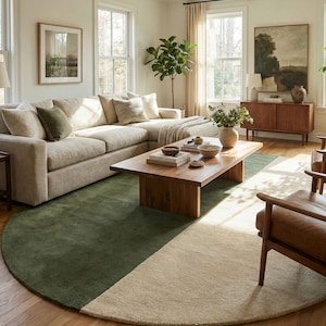 May include: A living room with a large beige sectional sofa, a wooden coffee table, and a half-circle rug. The rug is divided into two sections: a green section and a beige section. The room has large windows and a neutral color palette.
