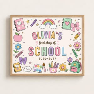 Peut inclure: Une impression encadrée avec le texte OLIVIA'S first day of SCHOOL 2026-2027 entouré d'illustrations colorées d'un arc-en-ciel, de cahiers, d'une pomme, de fleurs, de nœuds, d'un crayon, d'un pastel, d'une peinture et d'un sac à dos.