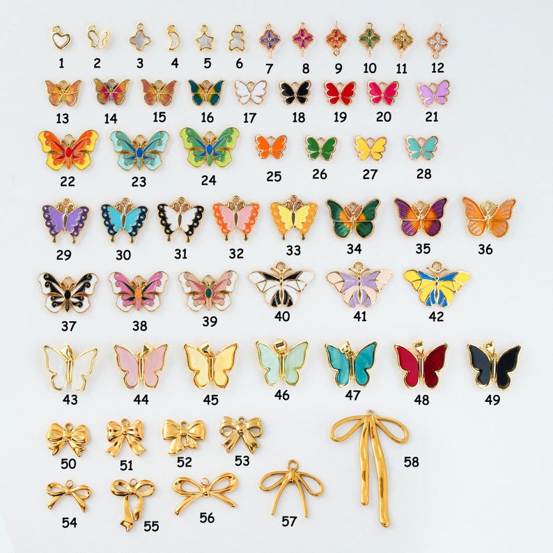May include: A collection of gold-toned and colorful butterfly and bow charms. The charms are numbered 1-58 and vary in size, shape, and color. Some charms have enamel details, while others are plain gold.