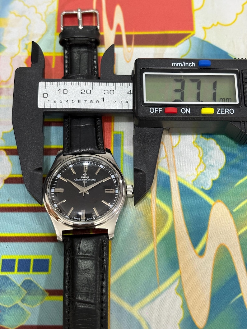 Close-up view of an authentic vintage Jaeger-LeCoultre Club watch dial, highlighting the elegant black dial design and fine detailing of this classic Swiss timepiece. The dial features clean hour markers, slim hands, and a timeless layout that reflects the refined craftsmanship of Jaeger-LeCoultre. This manual wind mechanical watch showcases precision engineering and vintage charm, making it highly desirable among collectors and watch enthusiasts.