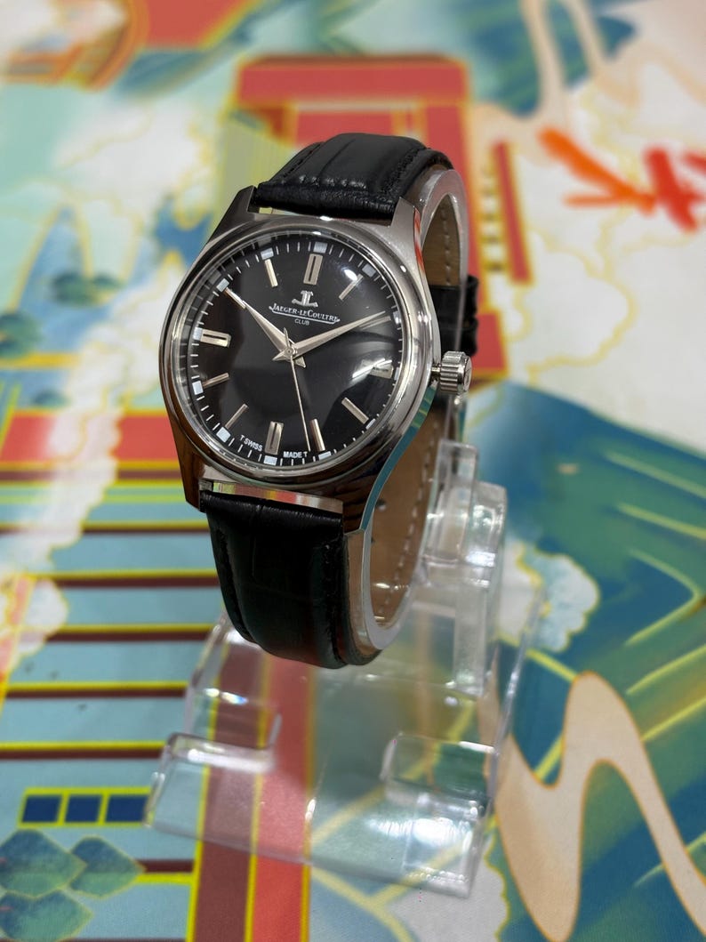 Authentic vintage Jaeger-LeCoultre Club manual wind watch featuring a classic black dial and timeless Swiss design. This elegant vintage wristwatch showcases a minimalist yet sophisticated aesthetic, with a clean black dial, slim markers, and refined hands that reflect the iconic craftsmanship of Jaeger-LeCoultre. The stainless steel case adds durability while maintaining a polished luxury look, making it a perfect vintage dress watch for men and collectors. This manual wind mechanical watch