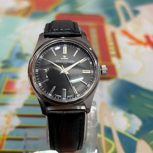 Ideal for watch collectors, vintage enthusiasts, and lovers of luxury timepieces, this Jaeger-LeCoultre Club watch stands out as a rare and collectible piece. Perfect as a gift for him, anniversary present, birthday gift, or festive season gift idea. This retro wristwatch pairs well with both formal and casual outfits, adding a touch of sophistication to any look. Keywords: vintage Jaeger-LeCoultre watch, black dial watch, manual wind watch, Swiss luxury watch, classic dress watch, collectible