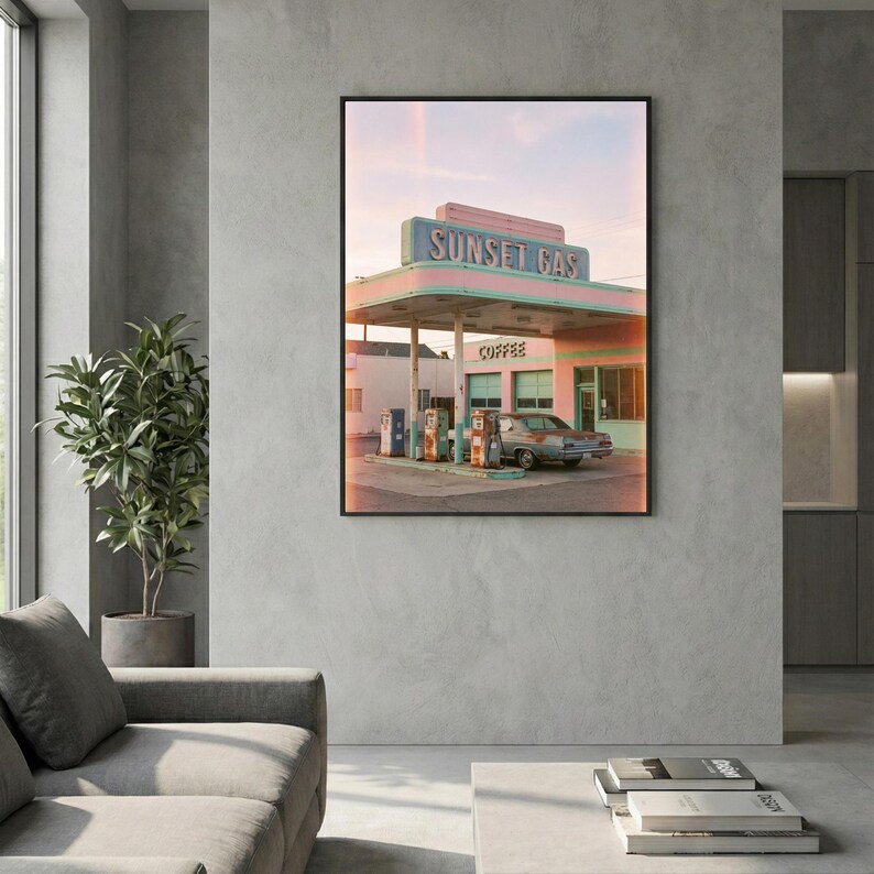 May include: A framed print depicting a vintage gas station, "Sunset Gas", in pastel shades. The gas station features a pink and teal colour scheme, with a classic car parked nearby. The word "Coffee" is visible on the building.