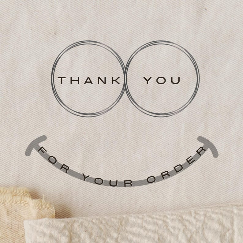 May include: A light beige fabric with a grey graphic. The graphic includes two overlapping circles with the words "THANK YOU" inside. Below, a curved line reads "FOR YOUR ORDER".