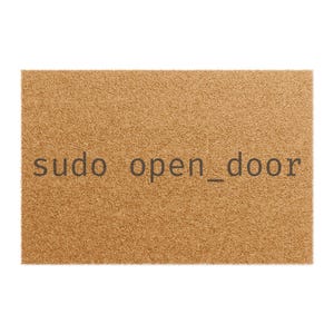Puede incluir: Una alfombra rectangular de color marrón claro y textura. Las palabras "sudo open_door" están impresas en gris oscuro en el centro. Esta alfombra está diseñada para su uso en la entrada.