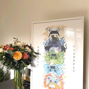 May include: A framed art print featuring a vertical design of stacked game controllers, each with a cat silhouette. The words "CONTROL YOURSELF" are printed vertically on the sides. The controllers are surrounded by flames and water.