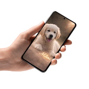 May include: A smartphone displays a smiling golden retriever puppy with the name "Milow" in a cursive font. The puppy has light brown fur and is lying down. The phone has a black frame.