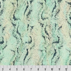 May include: A close-up of a soft, plush fabric with a swirling pattern in shades of teal, green, and white. The fabric has a fuzzy texture and a luxurious feel.