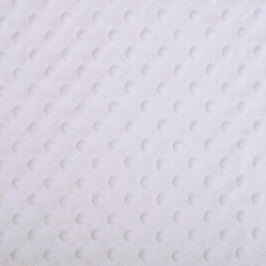 Pode incluir: Tecido branco texturizado com um padrão sutil de pequenos pontos em relevo.