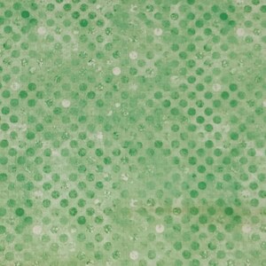 May include: A light green fabric or paper surface featuring a repeating pattern of darker green polka dots. The texture appears slightly mottled with subtle variations in color intensity and small, faint white spots scattered throughout the design.